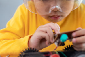 Inventive kid constructing robot cars at home